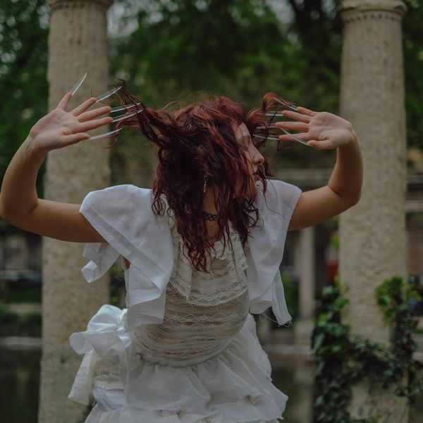 Woman performing a gentle, flowing movement in a calm setting.